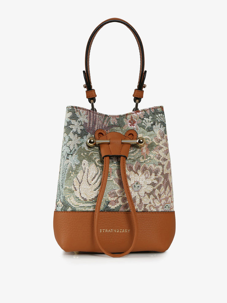 Wearable as a crossbody or carried in hand, this unique woven tapestry Strathberry drawstring leather bucket bag is compact and perfect for everyday. Collagerie.com