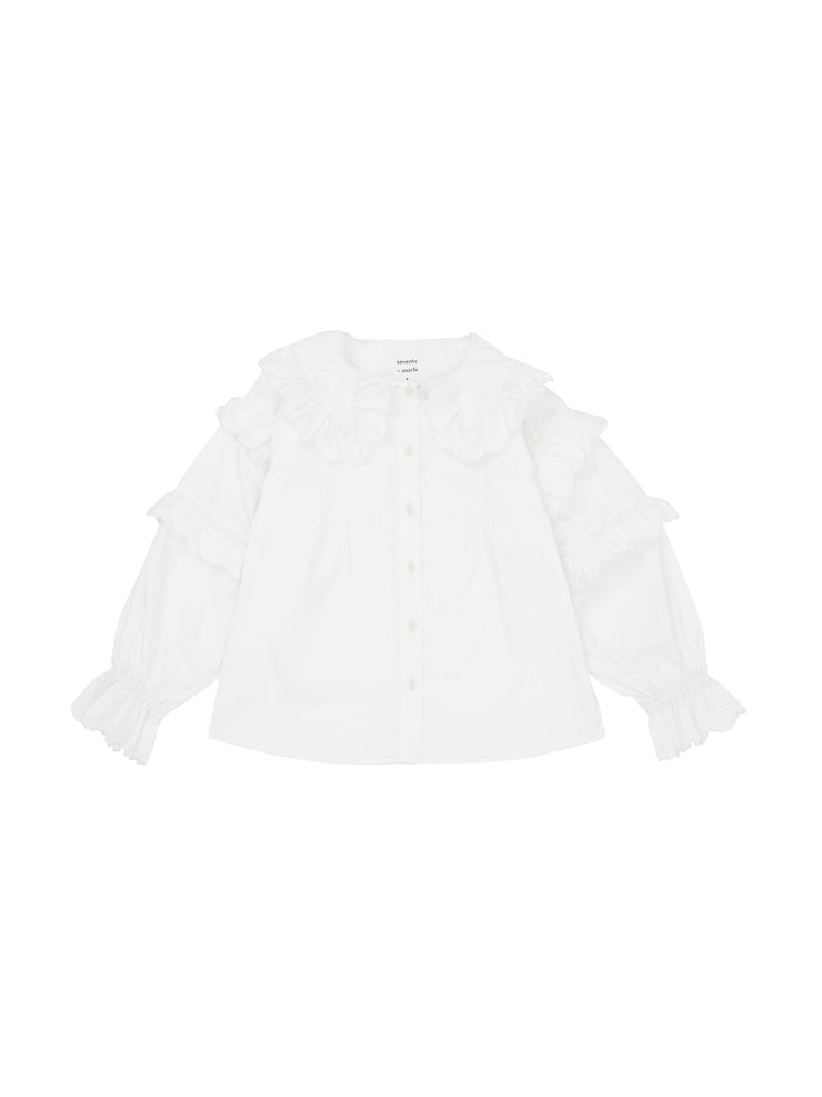 The ultimate goes-with-everything white Seventy + Mochi blouse with scalloped frill detailing and balloon-shaped sleeves. Made from organic cotton. Collagerie.com