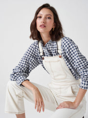 A must-have item for your forever wardrobe. This ecru white denim Seventy + Mochi dungaree features ankle-grazing hems and adjustable straps. Collagerie.com