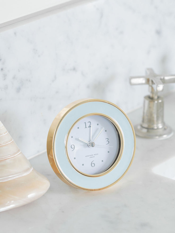 Soft powder blue enamel silent alarm clock finished in gold with a luxury dove grey velvet back by Addison Ross. Desk or bedside round clock | Collagerie.com